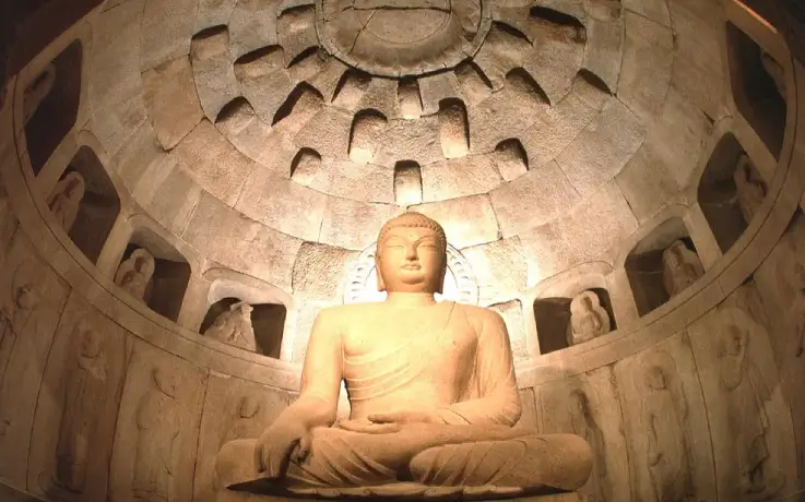 Interior view of Seokguram Grotto with a large stone Buddha statue