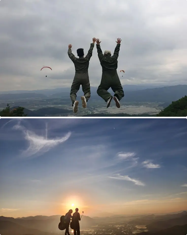People jumping joyfully with paragliders in the distance.