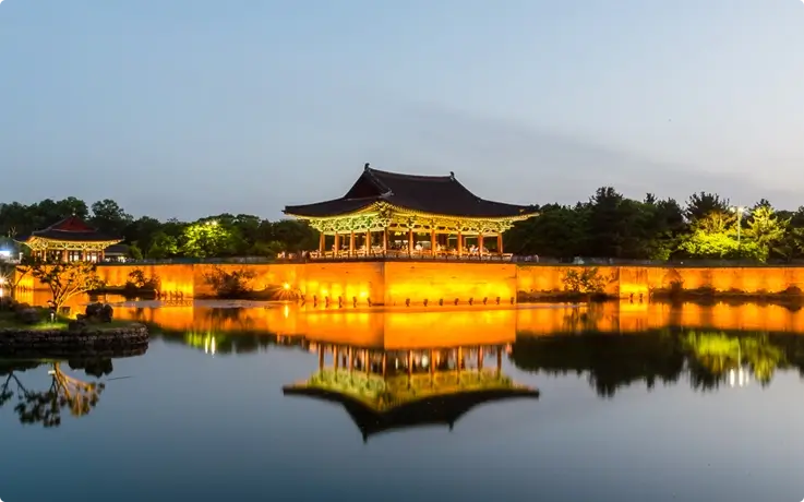 Donggung Palace and Wolji Pond illuminated at night, with reflections shimmering on the water.