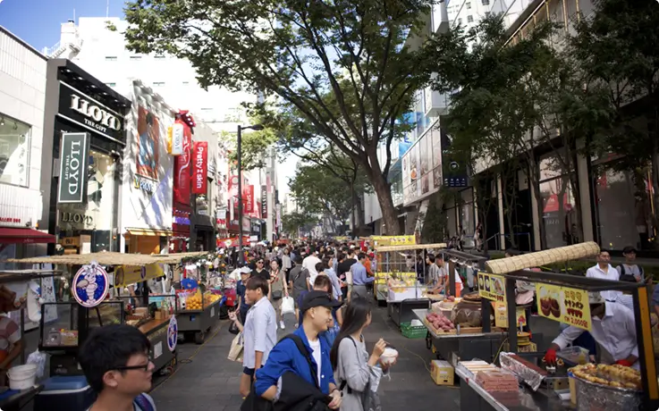 Lively Myeongdong shopping street lined with street food stalls.