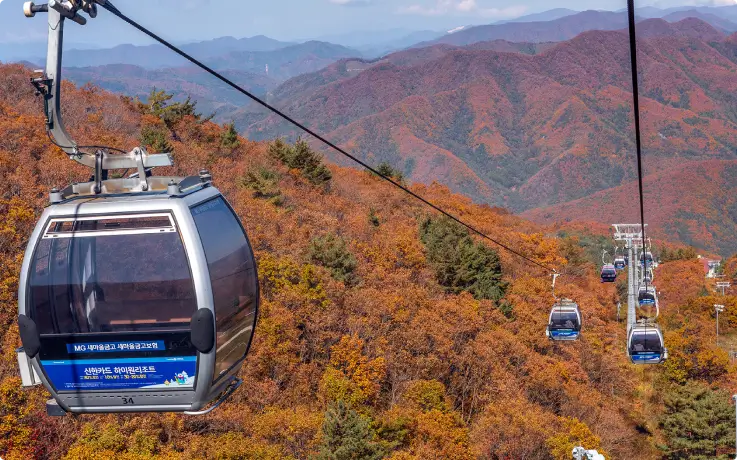 High1 Resort gondola cable car traveling over colorful autumn mountain scenery