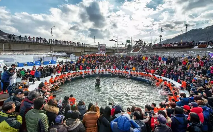 Crowds gathered around to watch the bare-hand fish catching experience at Hwacheon Sancheoneo Ice Festival.
