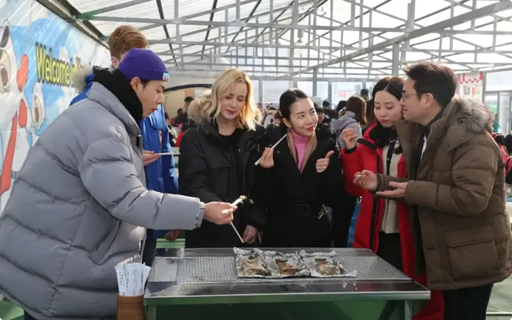 Visitors enjoying grilled fish at the Hwacheon Sancheoneo Ice Festival.
