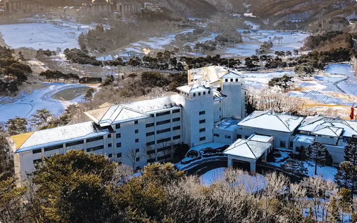 Birds-eye-view of Oak Valley Ski Resort covered in white snow, with ski slopes, lifts, and surrounding mountains.