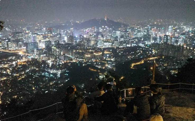 Visitors viewing Seoul night views from Inwangsan Mountain