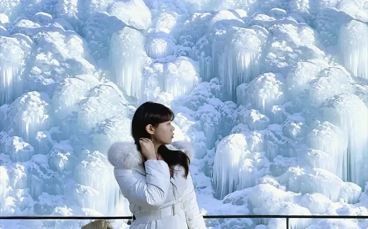 Visitor posing in front of an ice wall at Chorigol Cafe