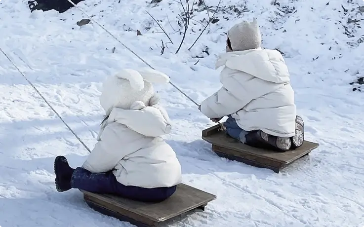 Visitors sledding at Chorigol Cafe in winter