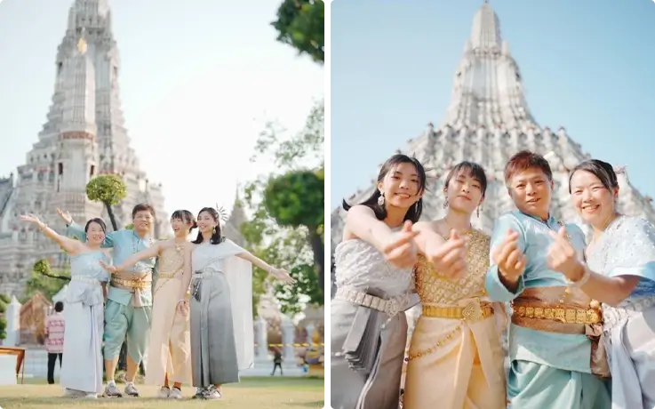 Visitors taking photos in Thai costumes near Wat Arun