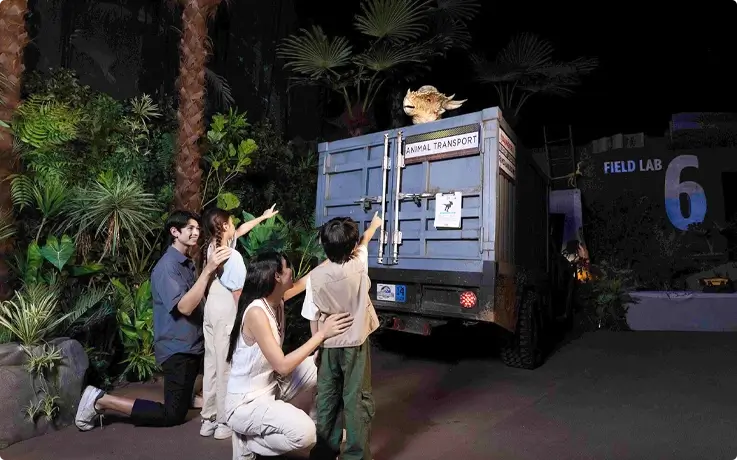 Visitors spotting a Stygimoloch at the crashed truck in Jurassic World: The Experience in Bangkok