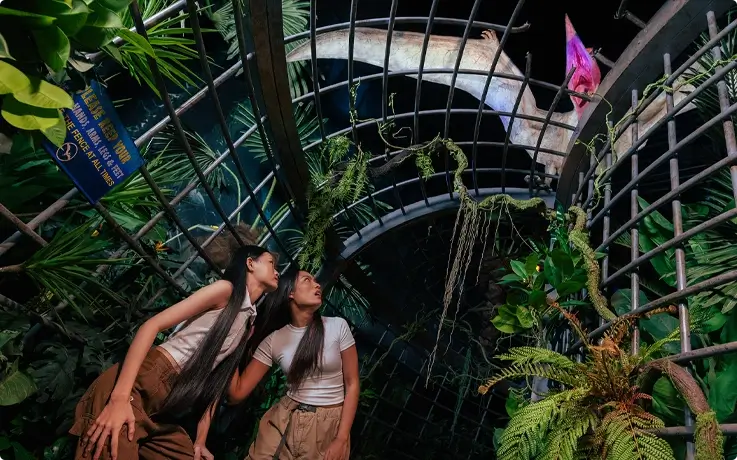 Visitors walking past the Caged Up zone with Pteranodons perched on the cave at Jurassic World: The Experience in Bangkok