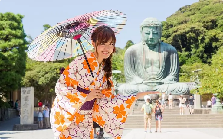 Visitor in Kimono taking photos with the Great Buddha of Kamakura