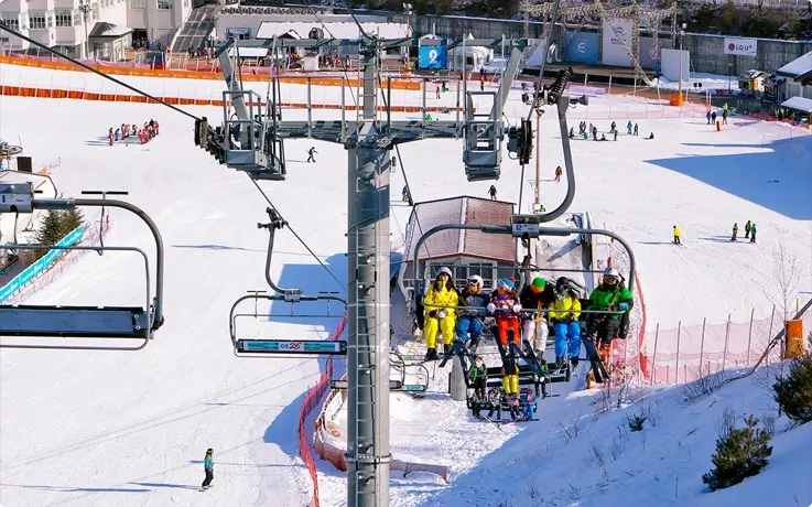 Visitors riding a ski lift at Elysian Gangchon Ski Resort