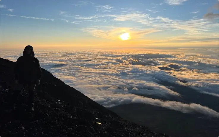 Visitor watching the sunrise from the Mt. Fuji summit