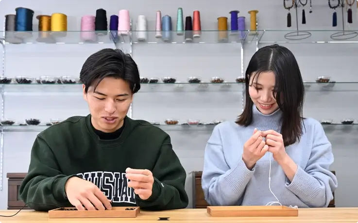 Visitors making prayer beads bracelet in Kyoto