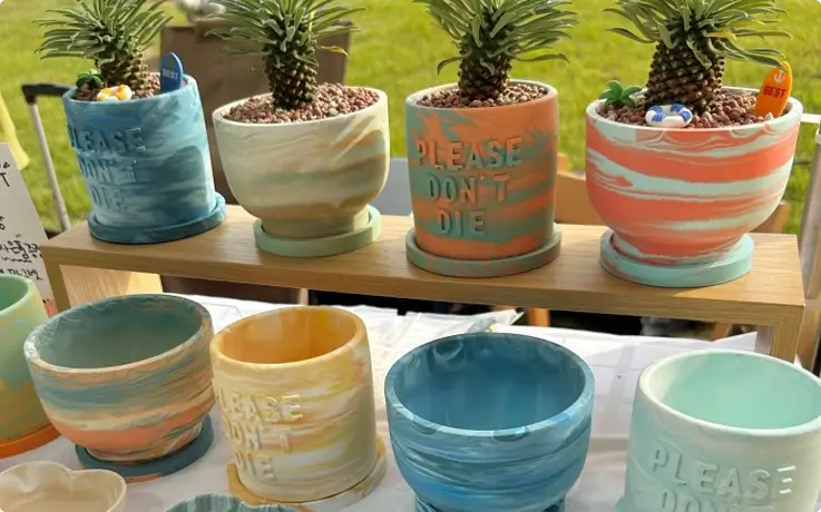 Round plant pot and 'Please Don't Die' pot made from eco-friendly resin at South Daze in Gwangalli, Busan
