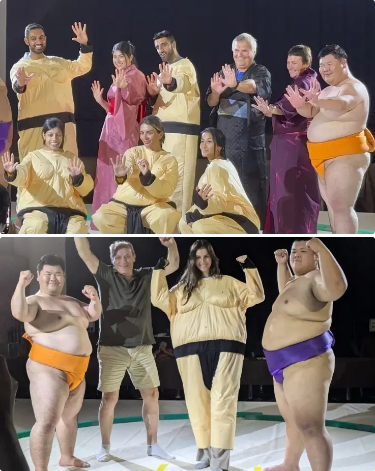 Visitors taking photos with sumo wrestlers with mawashi on