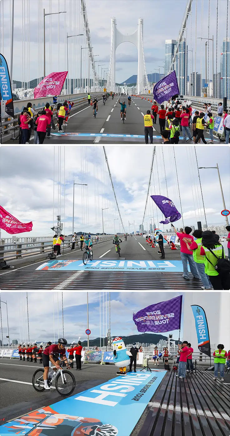 Riders celebrate crossing the finish line on Gwangan Bridge amid cheering volunteers.