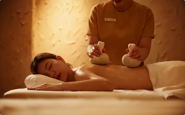 People getting pure oil massage with fresh herbal compress at Diora Luxe Asoke Spa in Bangkok