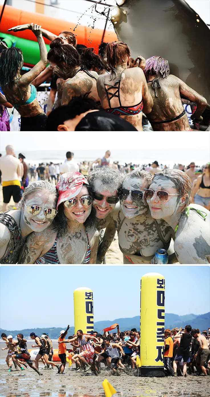 International visitors covered in mud, smiling and racing on Boryeong's beach.