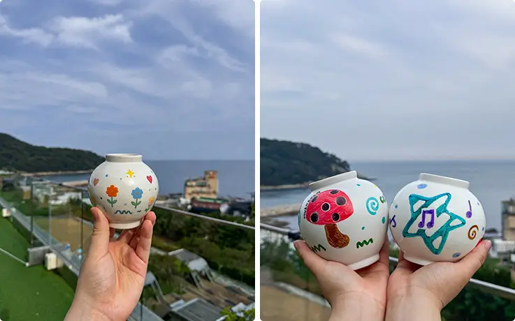 Hold hand-painted moon jars decorated with flowers, mushrooms, and stars overlooking ocean.