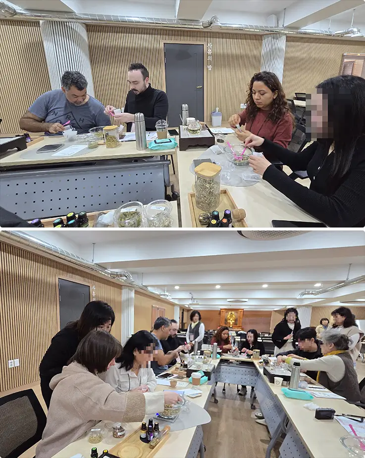 International participants crafting natural scent blends during an indoor aromatherapy workshop session.