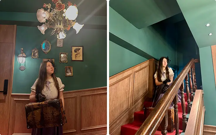 Guest in vintage costume poses beside antique portraits and a red-carpeted staircase.