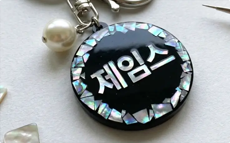 Handcrafted personalized Hangul name keychain with iridescent mother-of-pearl inlay design.