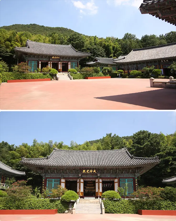 Naewonjeongsa Temple's grand main hall surrounded by lush forested mountains under a clear blue sky.