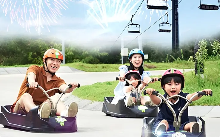 Families racing down a thrilling gravity-powered hillside kart track with coastal views.