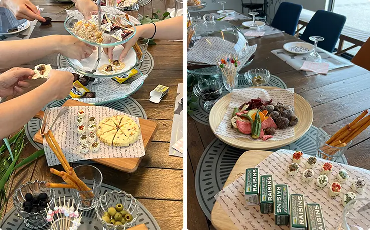 Elegant gourmet finger-food spread featuring artisanal cheese, olives, breadsticks, and raisin bites.