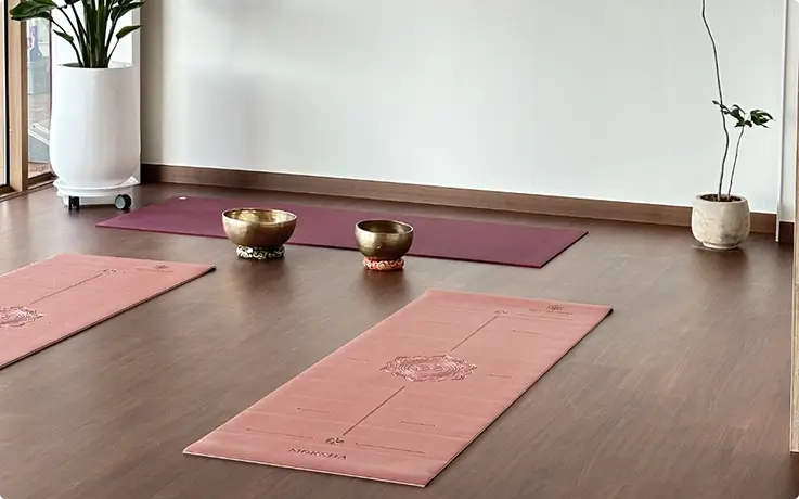 Yoga mats and singing bowls set up in a calm studio.
