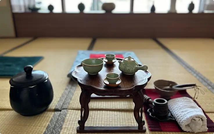 Traditional tea set arranged on a low table for tea ceremony.