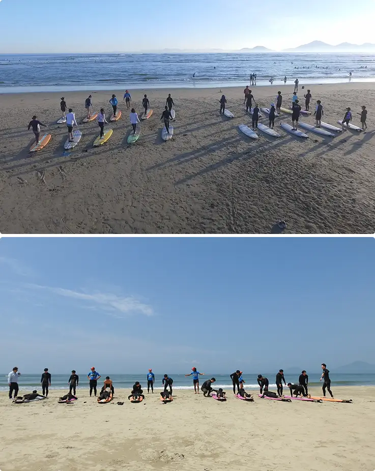 Beginner surf lesson group lined up on Dadaepo Beach with boards ready.