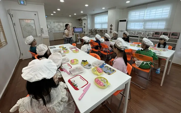 Children in chef hats join a fun hands-on Korean cooking class together.