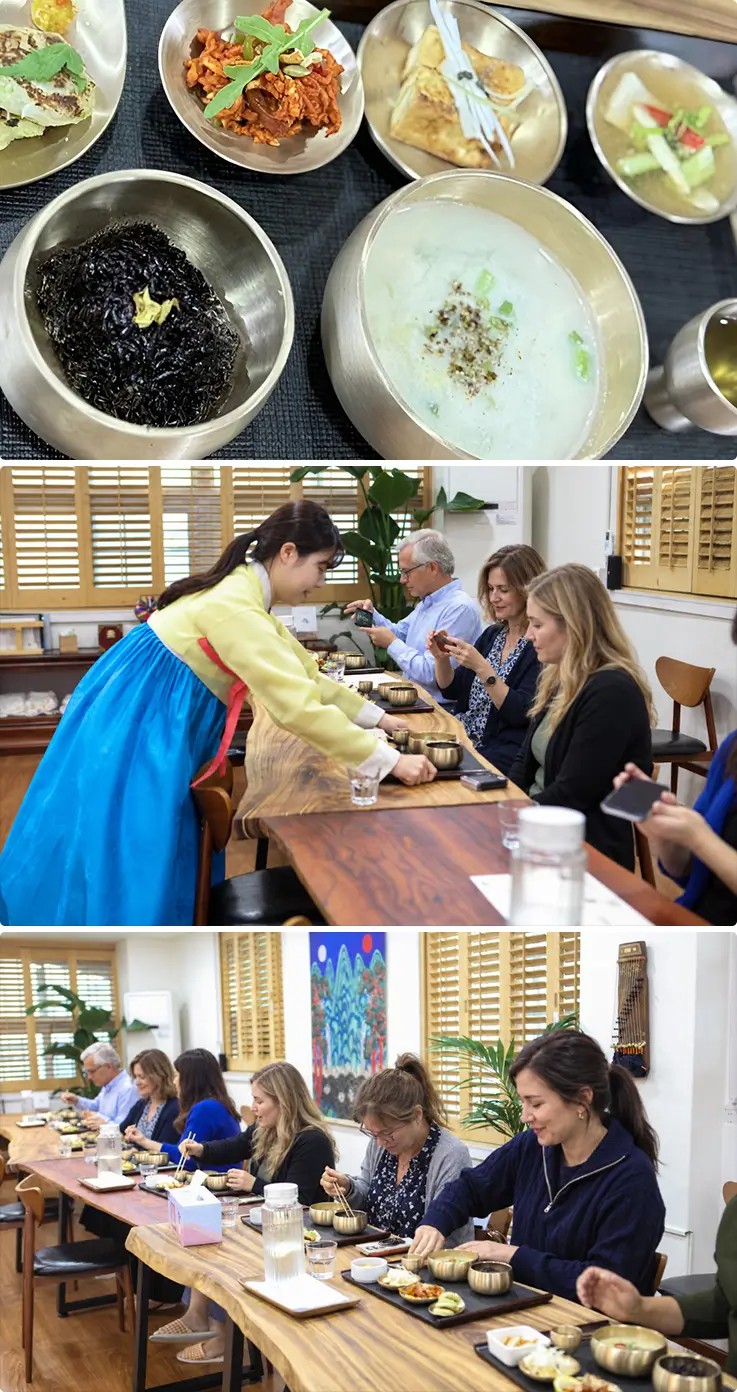 A hanbok-clad host serves a traditional Korean table filled with local dishes.