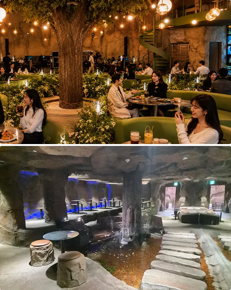 People relaxing inside a whimsical forest-themed café with cozy cave-style seating.