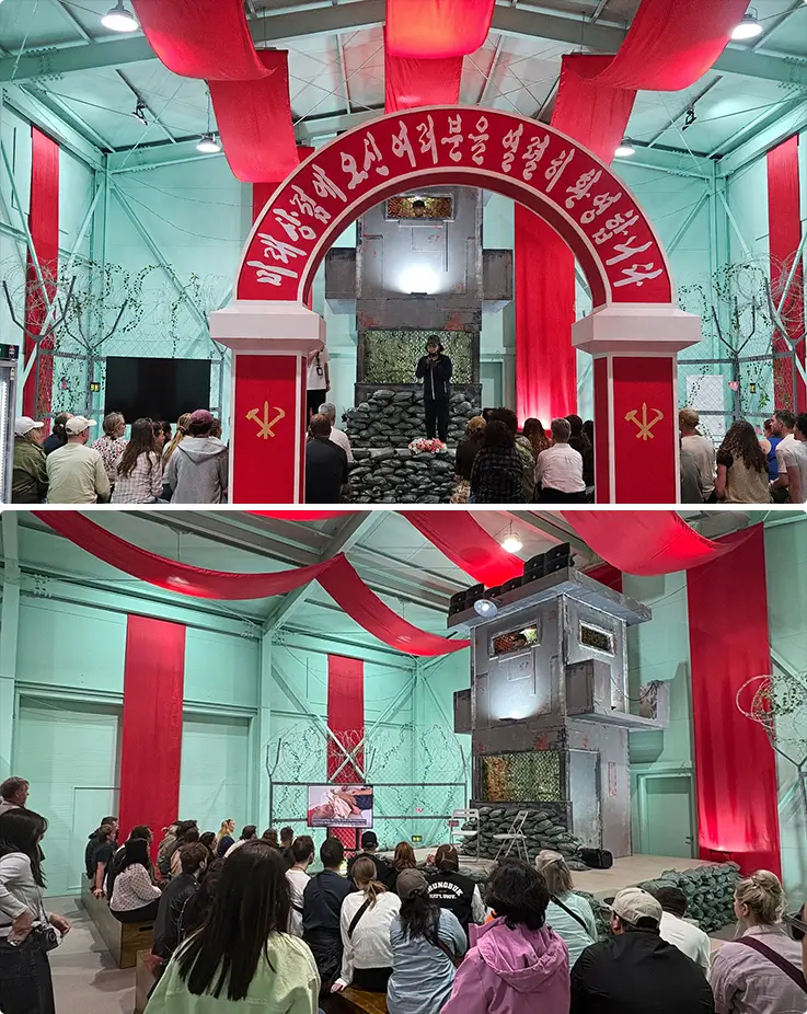 Tourists explore immersive North Korea DMZ Experience Hall with replica guard tower.