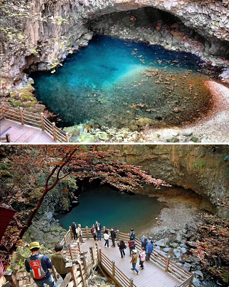 Emerald waterfall pool hidden within dramatic volcanic canyon scenery and cliffs.