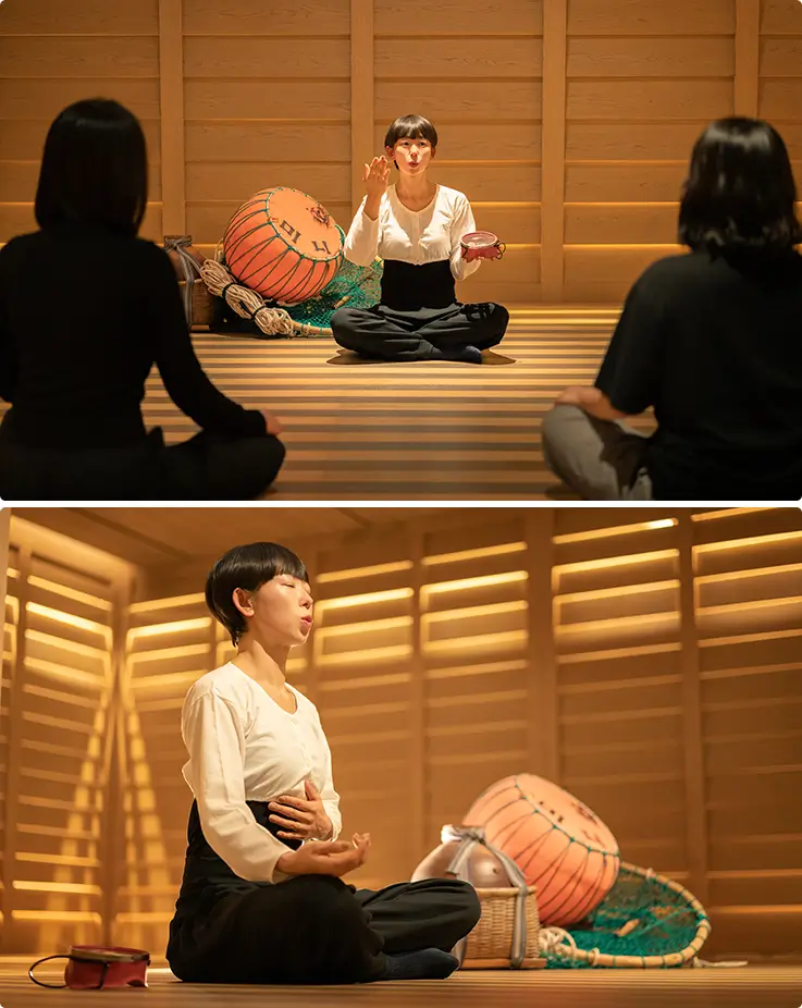 Haenyeo shares breathing storytelling and sumbisori sound in cozy wooden meditation room.