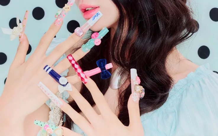 Playful Ang:tt long nail extensions decorated with bows, buttons, gingham, and pastel charms.