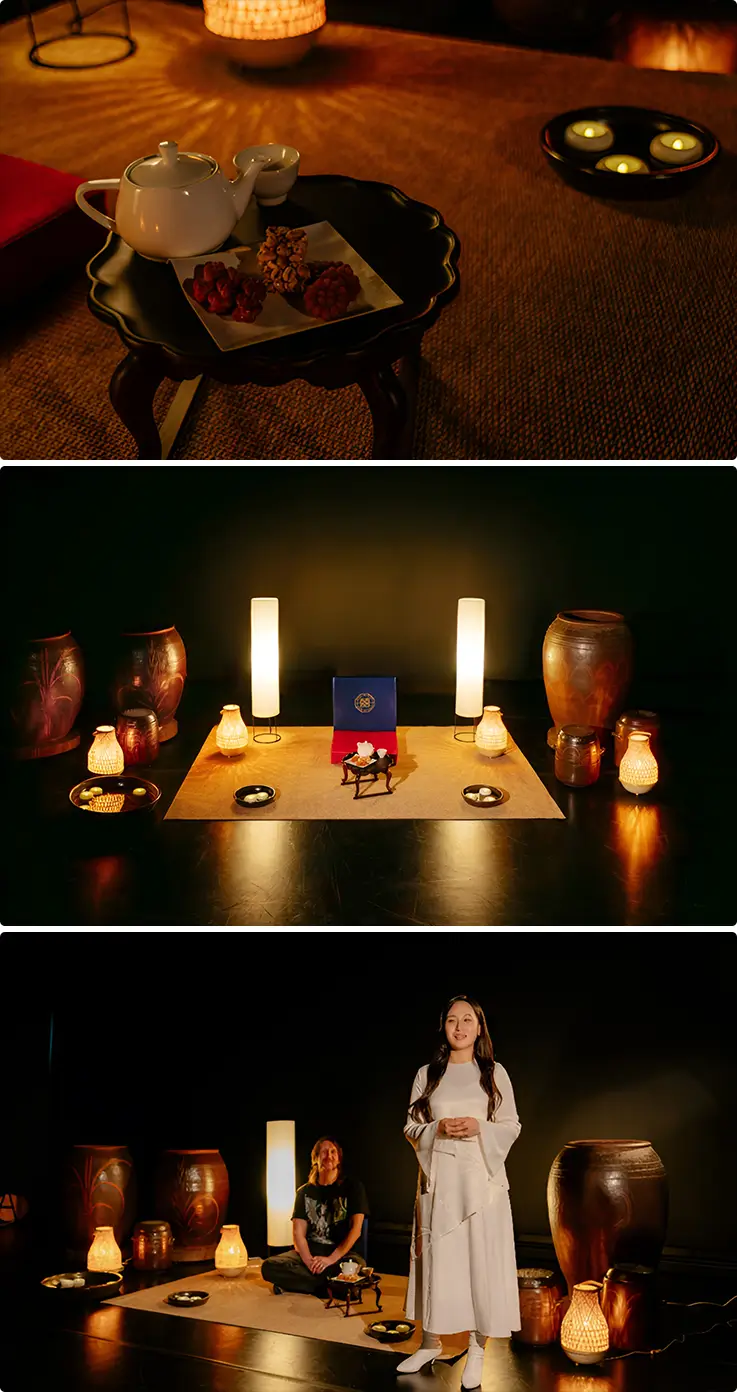 Individual table service with traditional Korean tea and sweets, candlelit Black Room stage, and a performer welcoming a seated guest.