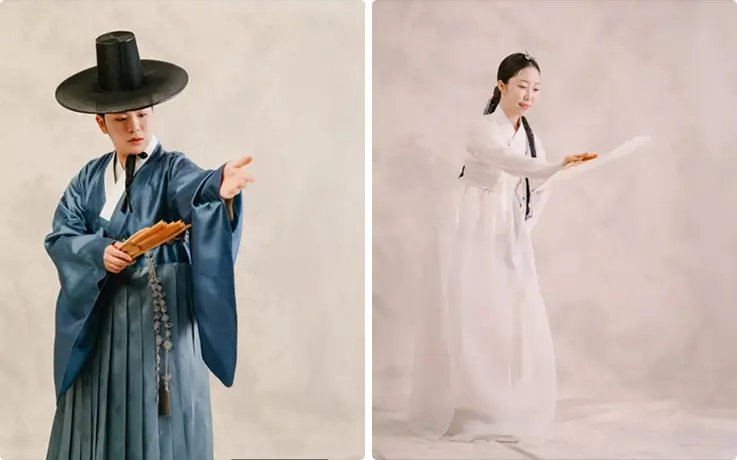 Master performers in traditional Korean attire presenting fan dance and graceful Korean traditional dance on stage.