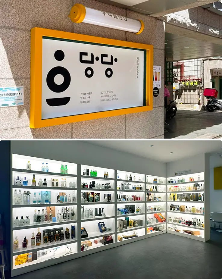Bright yellow bottle shop signage beside shelves stocked with traditional Korean spirits.