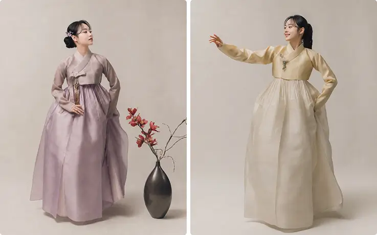 The pansori instructor poses gracefully in elegant lavender and soft yellow hanbok attire.
