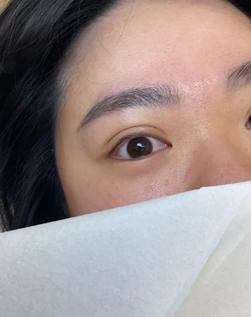 Close-up of freshly done natural Korean eyebrow PMU with soft, hair-like strokes.