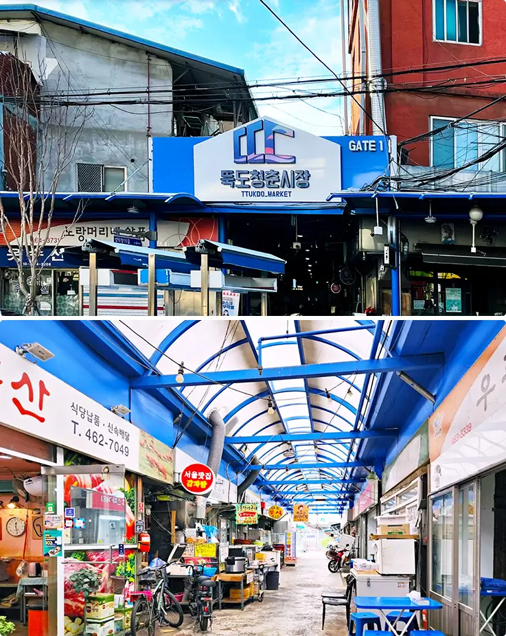 Blue-roofed market entrance leading into a bustling row of local food vendors.