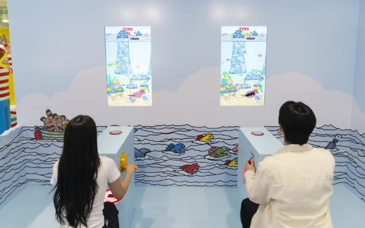 Two players compete in an ocean-themed fishing arcade game on side-by-side screens.