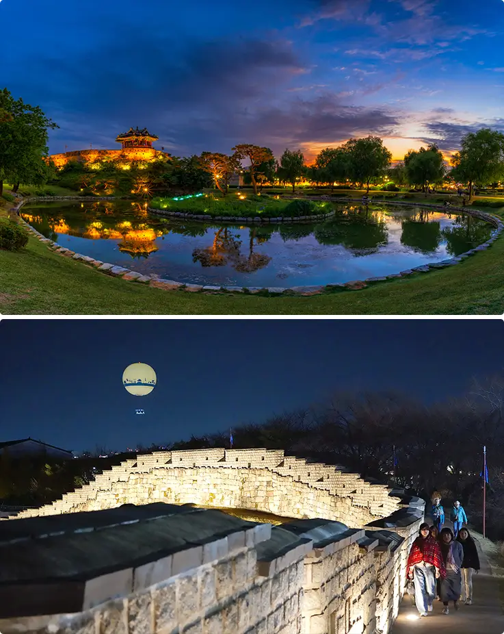 Hwaseong Fortress lit up at night with pavilion reflected in pond.