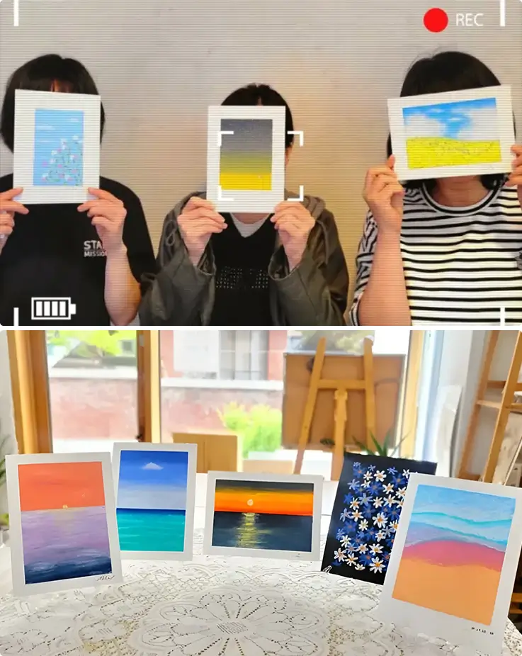 Guests display finished Suwon oil pastel keepsakes featuring sunsets, seascapes, and flowers.
