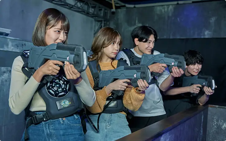 Visitors enjoying laser shooting game at Tokyo Joypolis